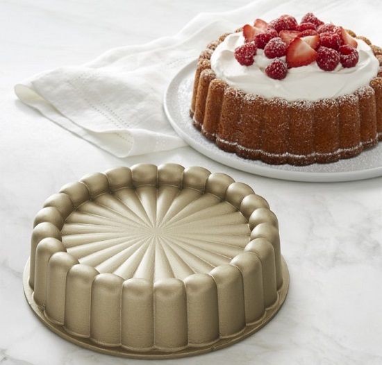 two cakes sitting on top of a table next to each other, one is covered in icing and the other has strawberries