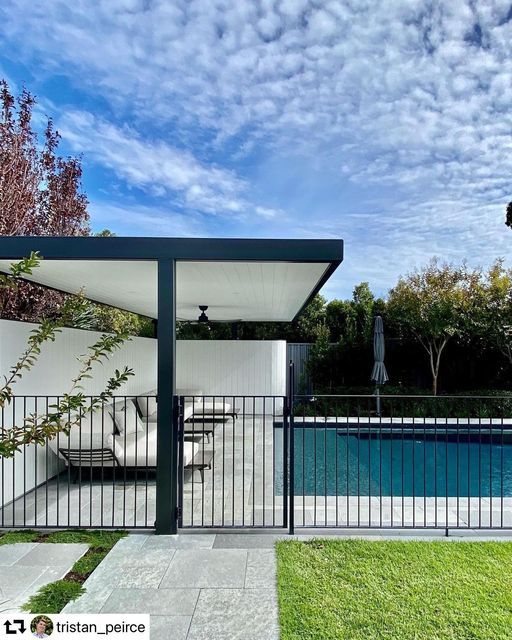 an outdoor pool area next to a fence