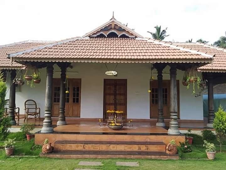 a small white house with two porches and pillars