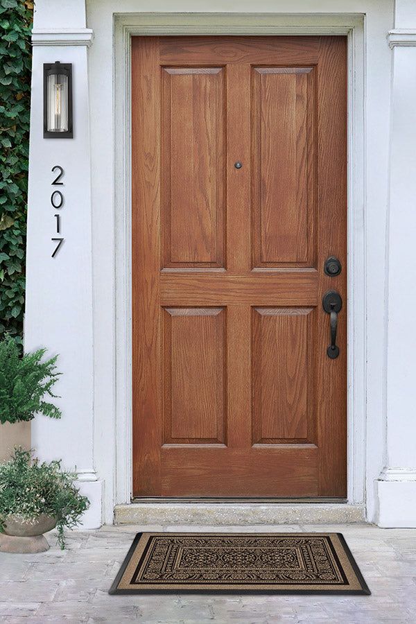 a wooden door is shown in front of a house with potted plants on either side