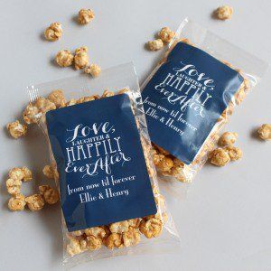 two bags of popcorn sitting next to each other on a white counter top with blue tags that say love and happily together