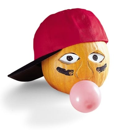 an orange with a red hat and nose blowing a bubble