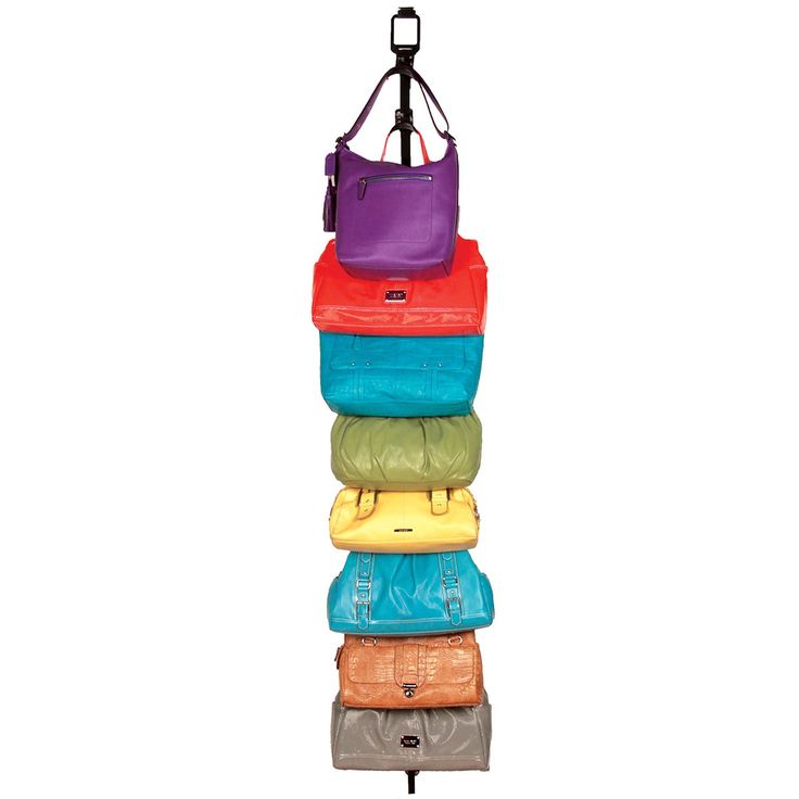 a multicolored bag hanging from a hook on a white wall with five bags stacked in it