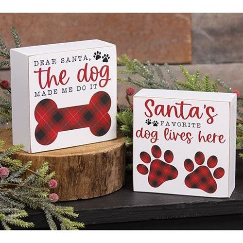 two boxes with dog prints on them sitting next to evergreen branches and pine cones in the background