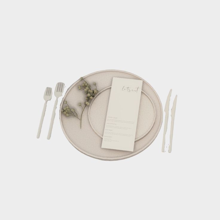 a white plate with silverware and napkins on it next to a fork, knife and spoon