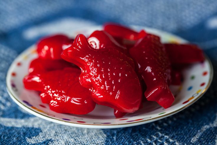 a white plate topped with red fruit on top of a blue table cloth