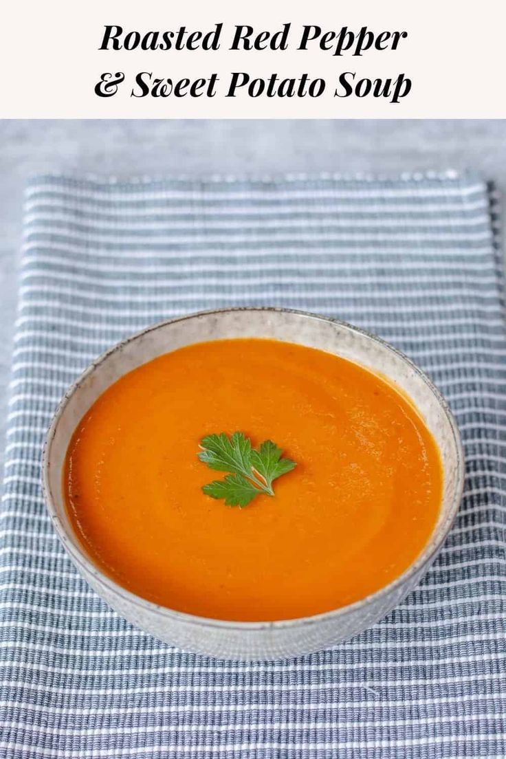 a bowl of roasted red pepper and sweet potato soup with parsley in the middle