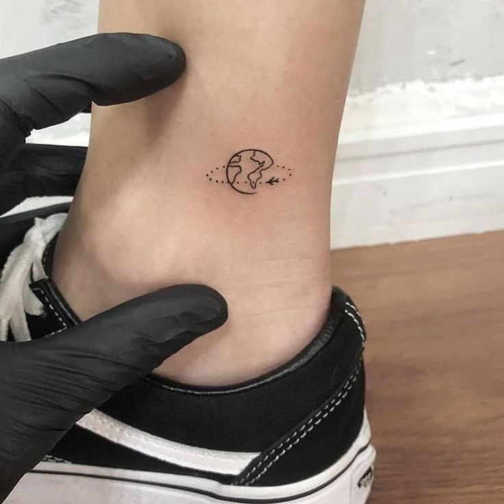 a woman's foot with a small tattoo on the side of her ankle,