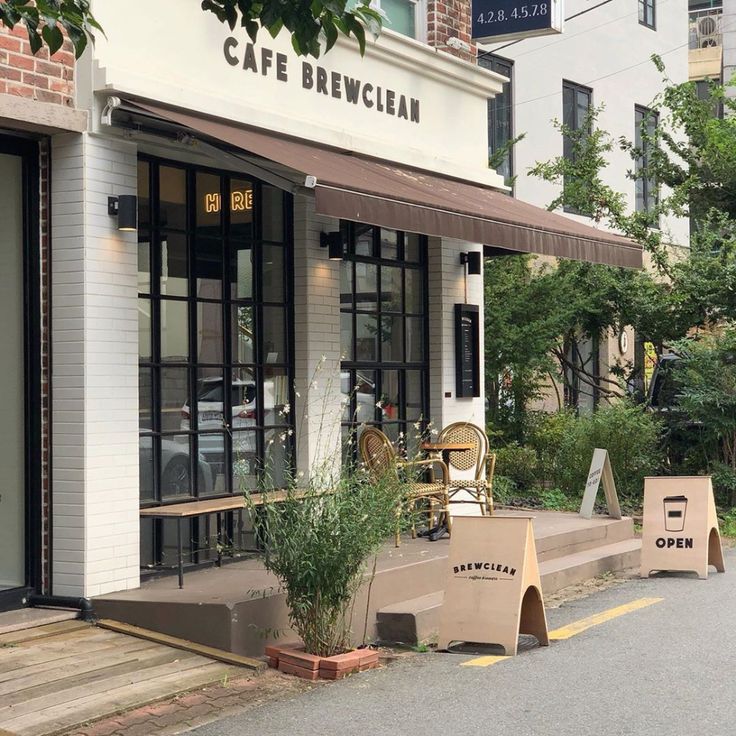 the outside of a cafe with chairs and tables