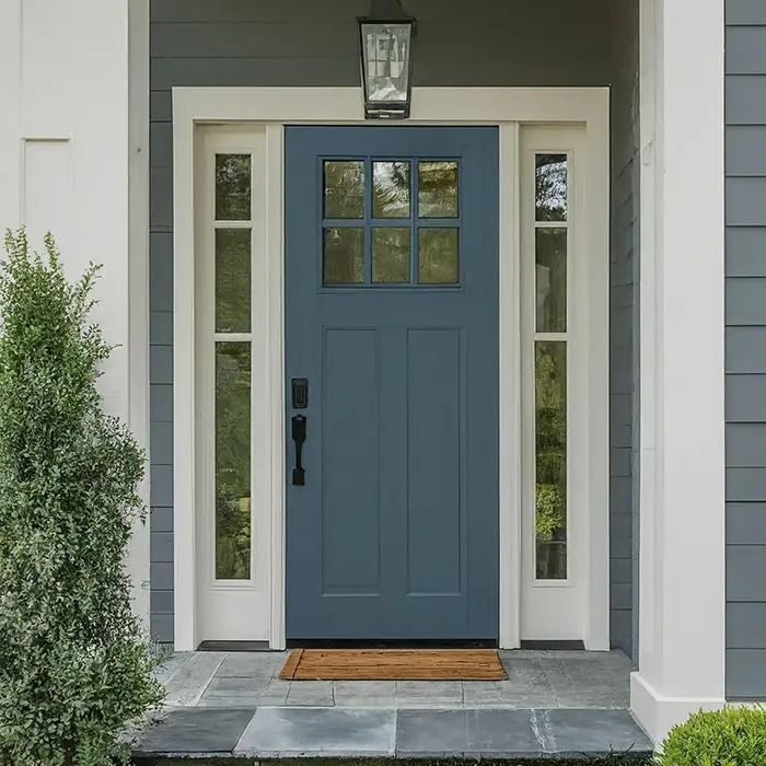 a blue front door with white trim and two sidelights on the outside of it