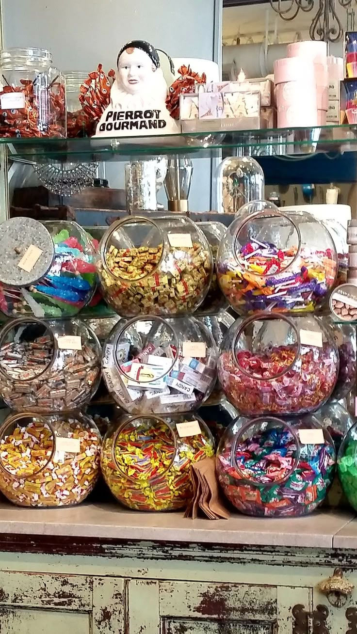 a display case filled with lots of different types of candies and candy in glass bowls