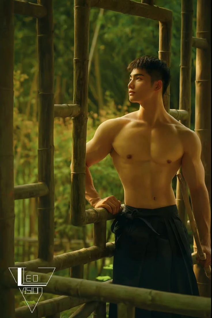 a shirtless man standing in front of a bamboo structure with his hands on his hips