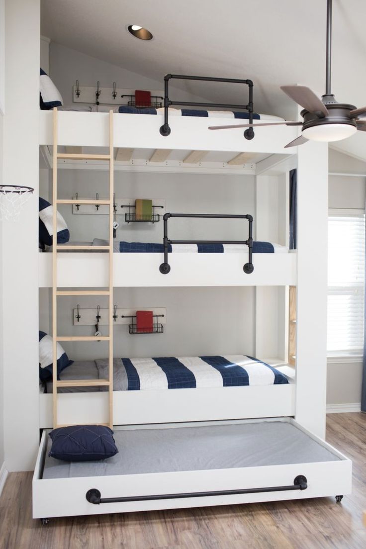 a bunk bed with ladders is in the middle of a room that has hardwood floors and white walls