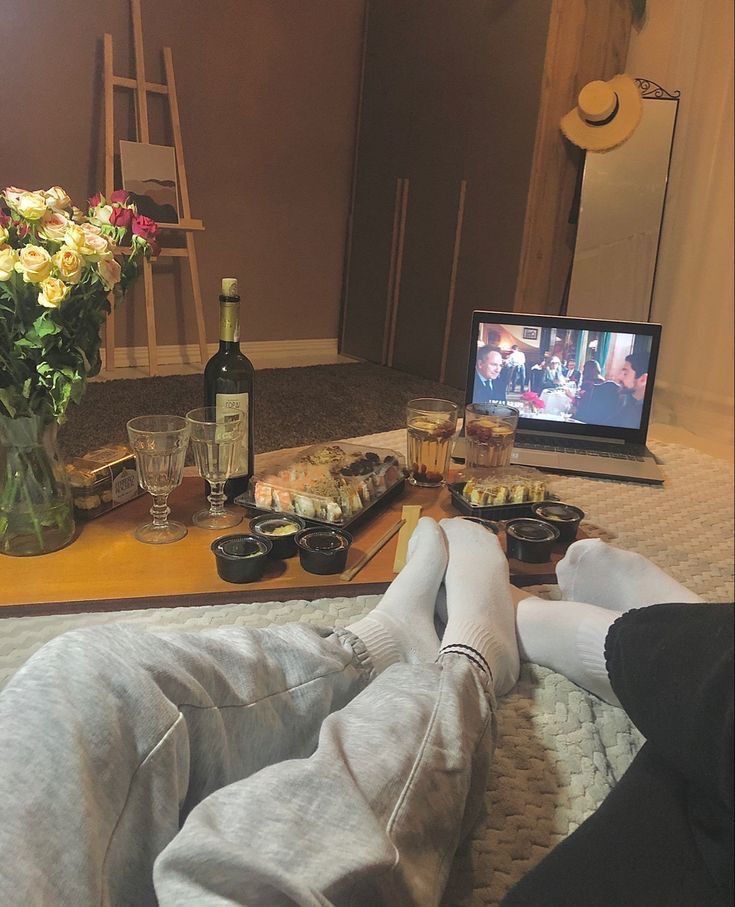 a person laying on the floor with their feet propped up in front of a tv