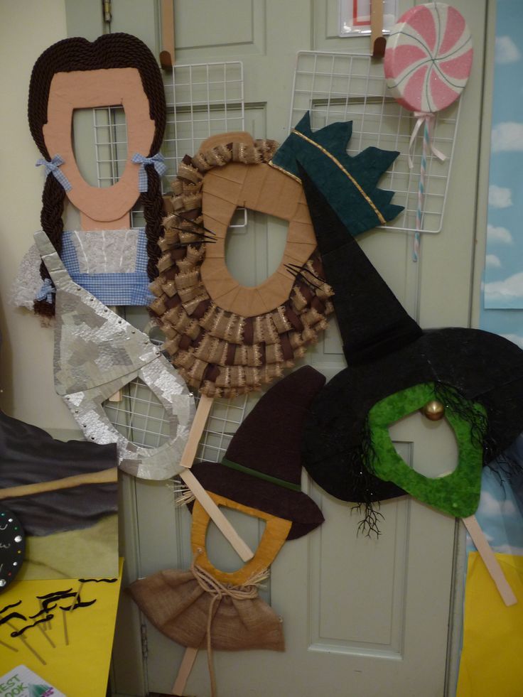 a bunch of hats hanging on a wall next to a door with paper decorations around them