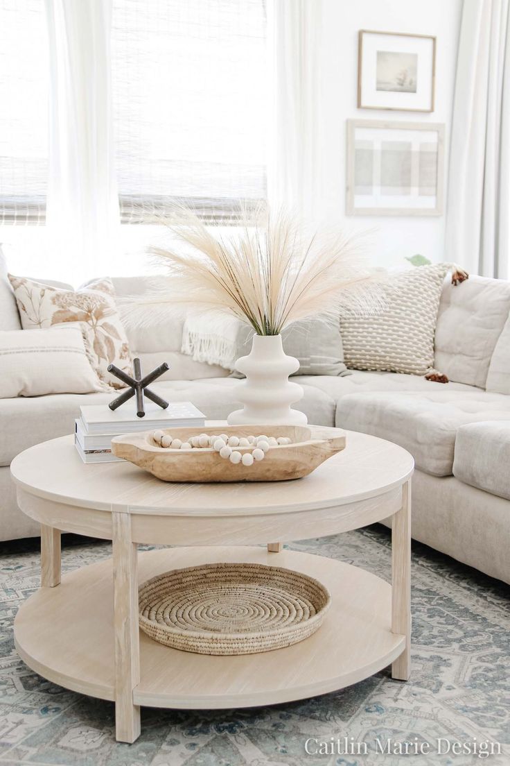 a living room filled with furniture and a white coffee table in front of a window