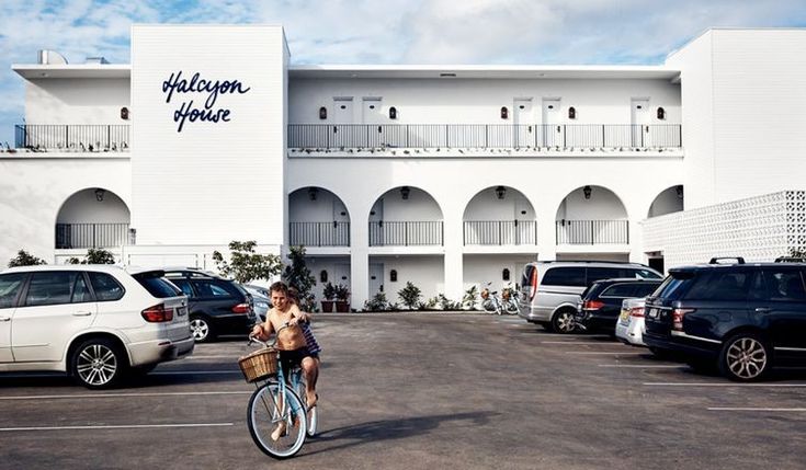 a woman riding a bike in front of a white building