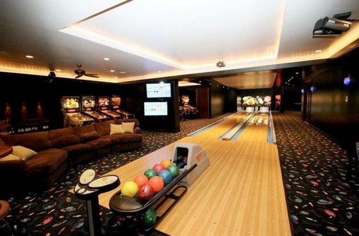 a bowling alley with couches and bowling balls on the floor in front of them