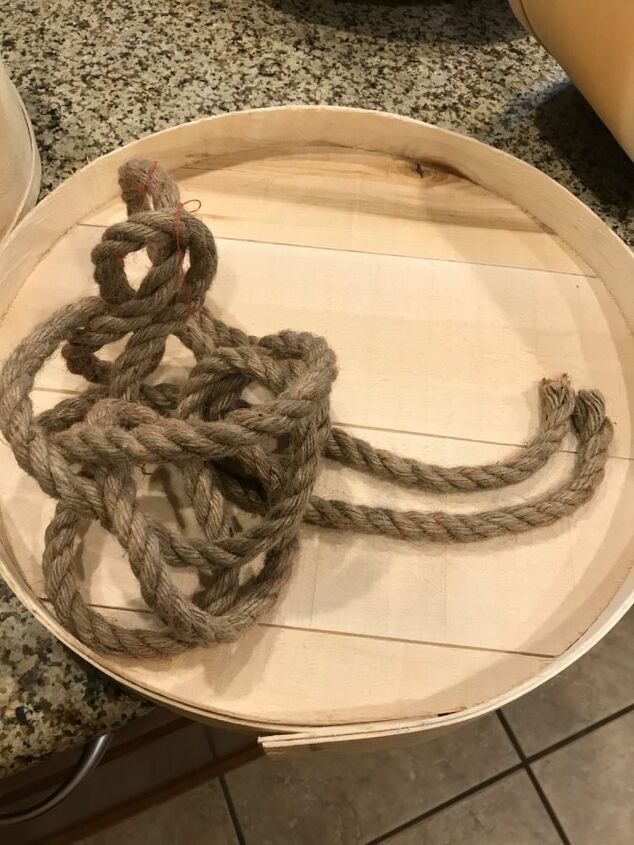 a wooden bowl with rope in it sitting on a counter