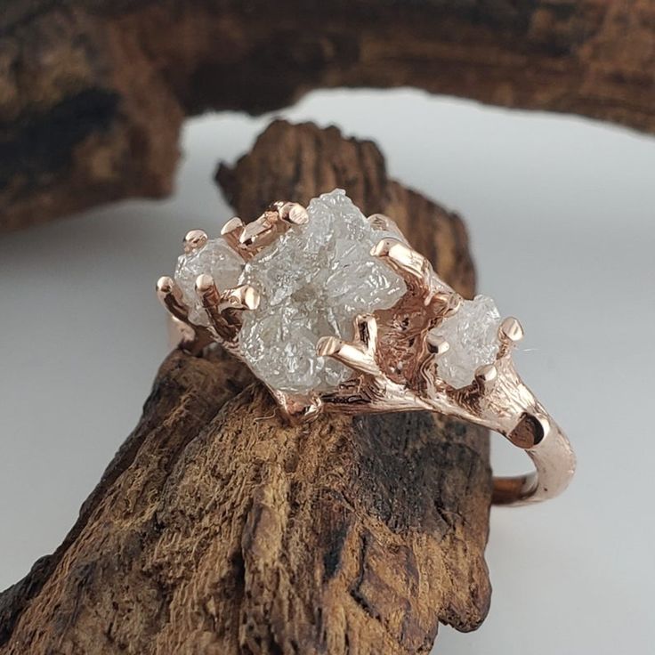 a rough diamond ring sitting on top of a piece of wood