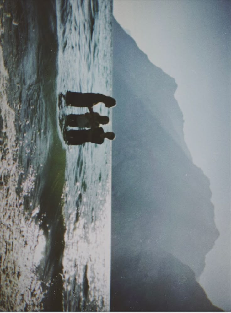 two people standing on the edge of a cliff