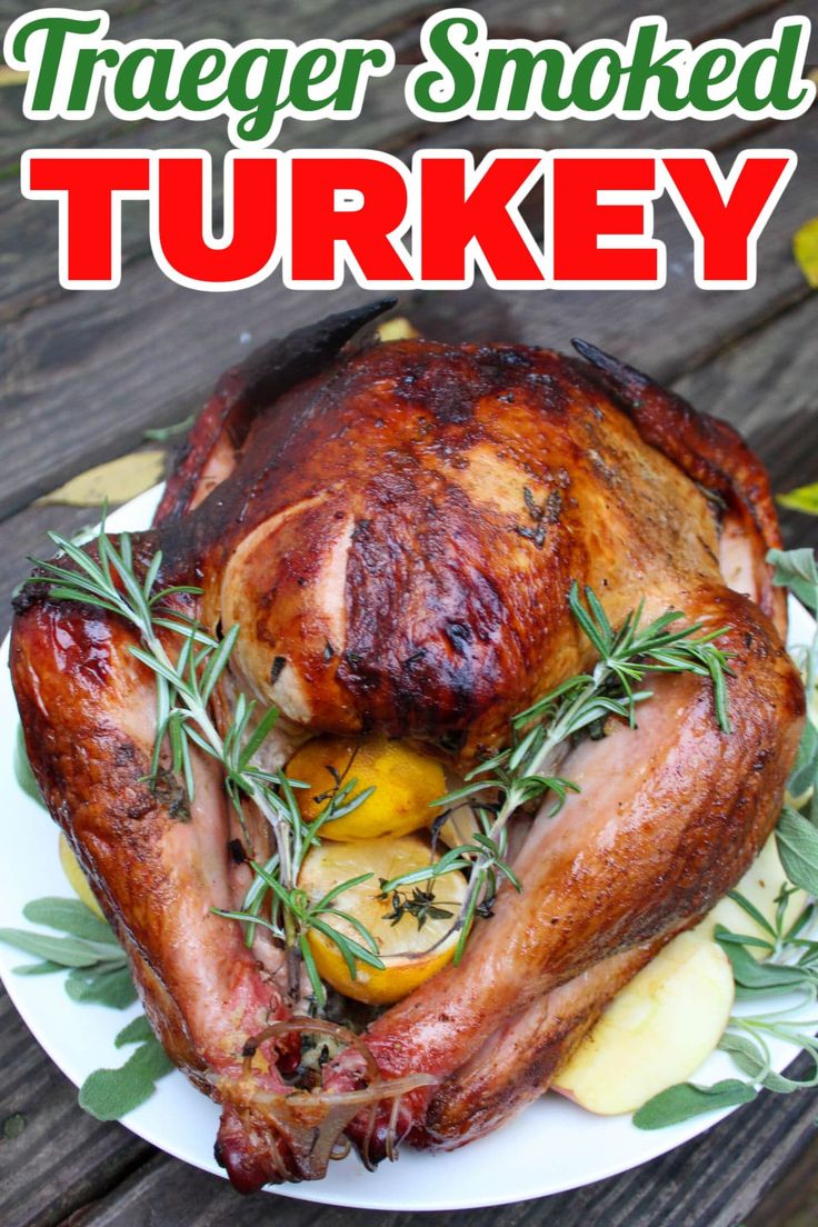 a turkey on a plate with herbs and lemons in the foreground text reads traeger smoked turkey