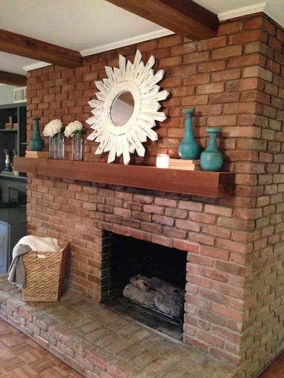 a brick fireplace with a mirror and vases on top