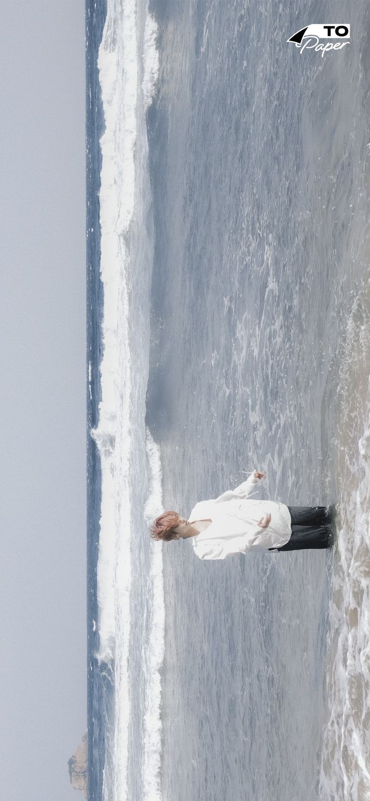 a woman in white is standing on the beach