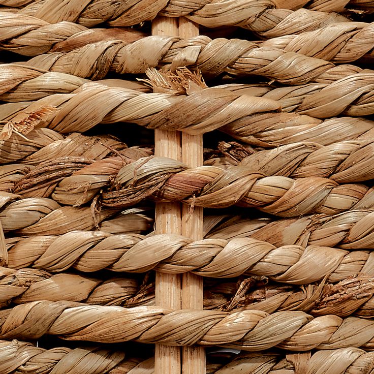 a close up view of some kind of woven material with wood poles in the background