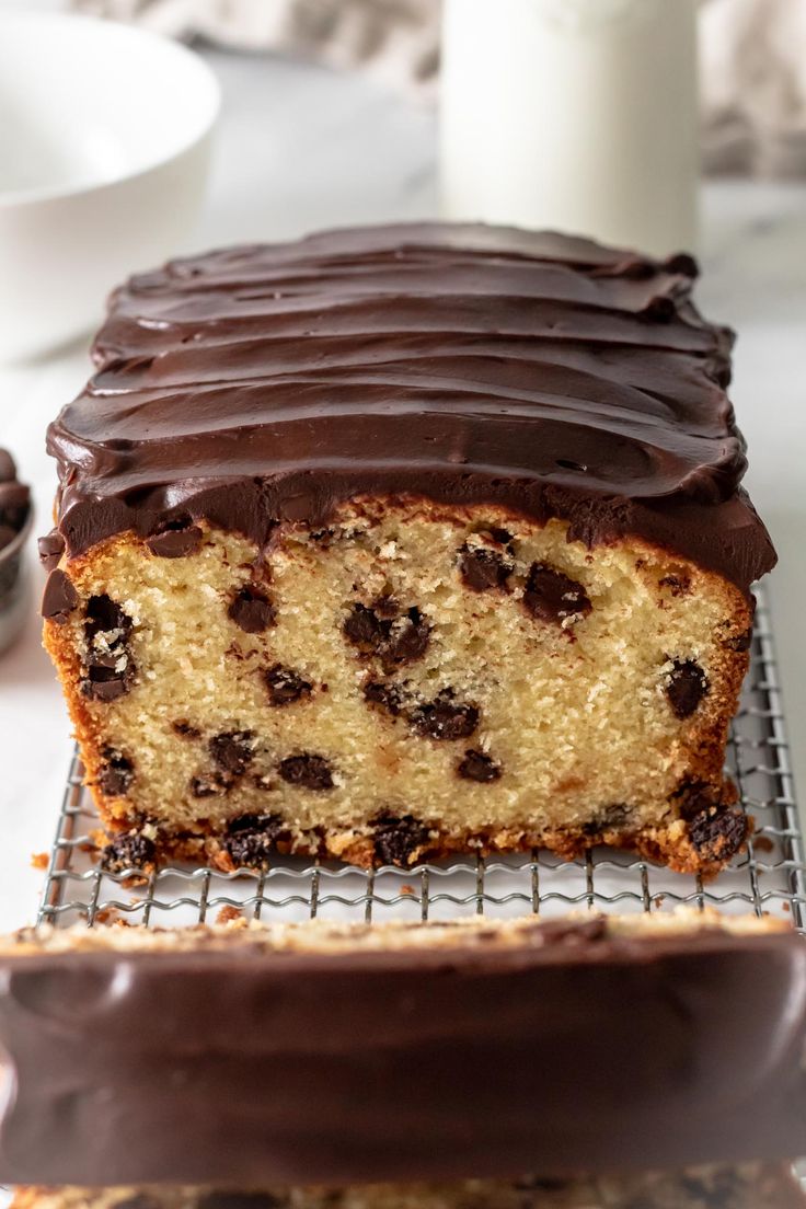 a chocolate chip cake on a cooling rack with one slice cut out and ready to be eaten