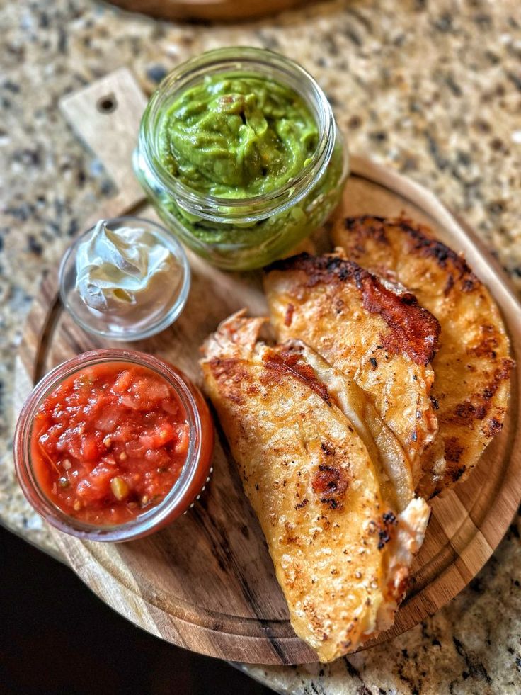 some food is sitting on a plate with sauces and condiments next to it