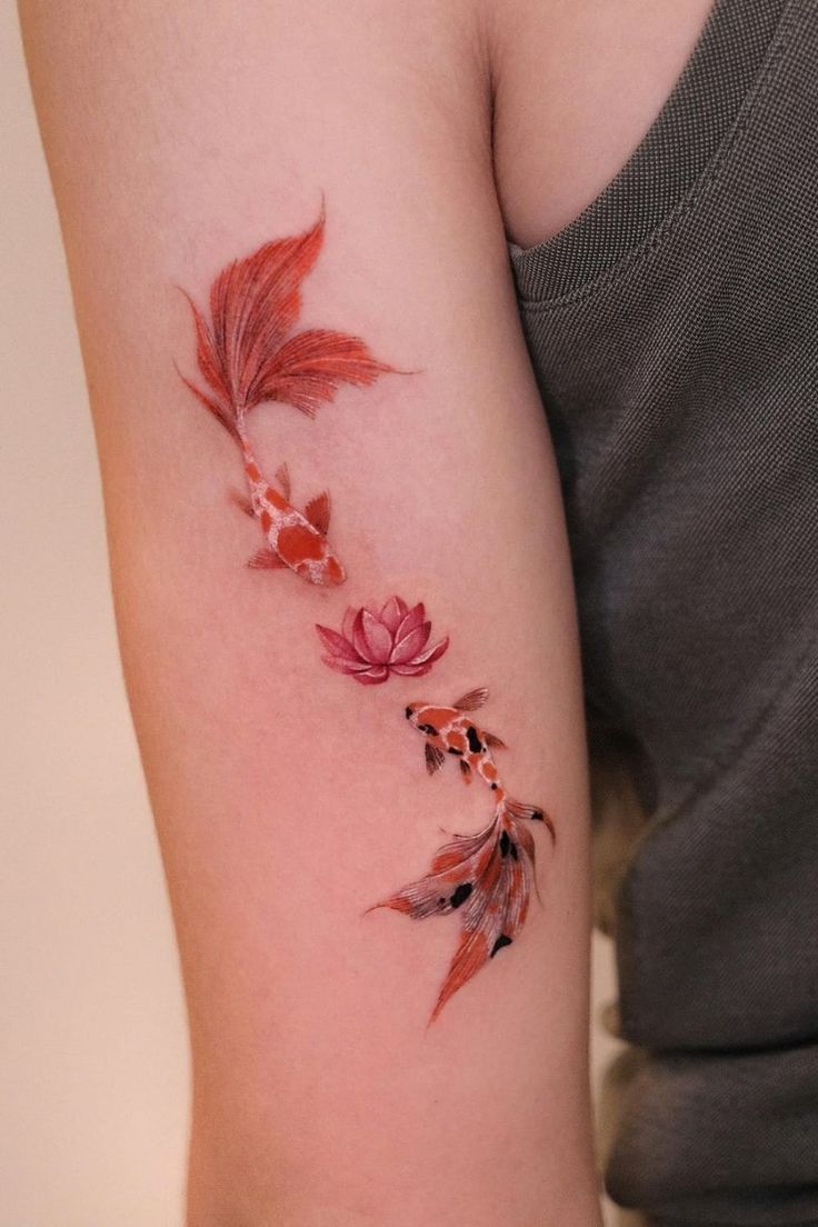 a woman's arm with red flowers and leaves on it