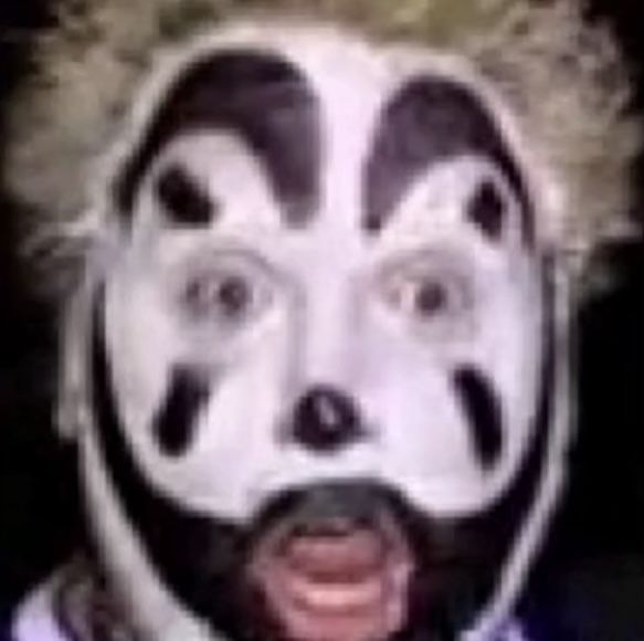 a man wearing a clown mask with his face painted black and white to look like he is smiling