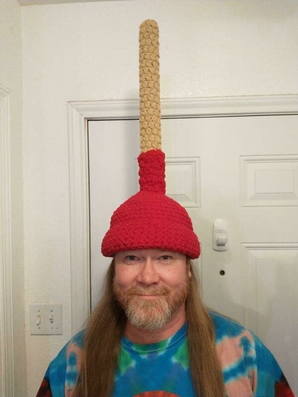 a man with long hair wearing a red knitted hat on top of his head