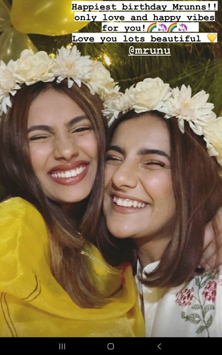 two women are smiling for the camera with flowers in their hair