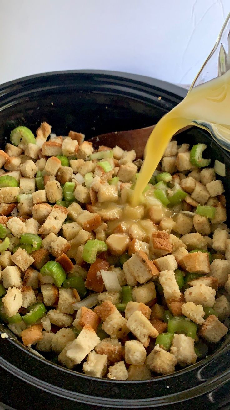 the food is being poured into the slow cooker to make stuffing for croutons