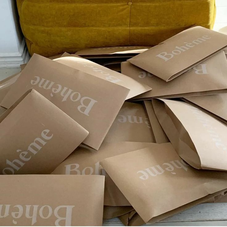 a pile of brown paper bags sitting on top of a wooden floor