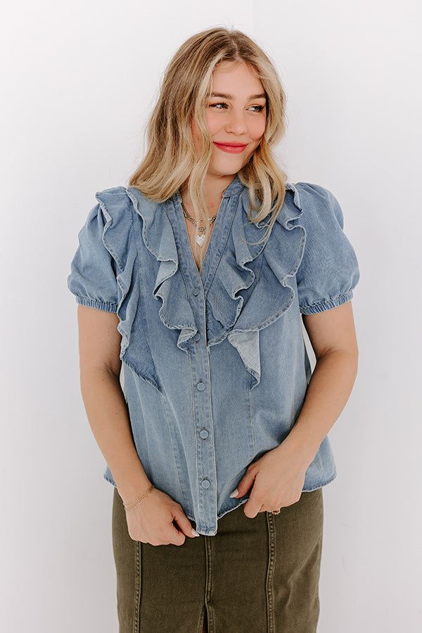 - Stay casual-cool with this ruffled denim top! - Unlined non-stretch denim material - A v-cut neckline - A buttoned front - A ruffle detailed bodice - Short sleeves with elastic cuffs - A relaxed silhouette that ends in a straight hemline Chic Light Wash Chambray Denim Top, Light Wash Chambray Denim Top For Day Out, Medium Wash Denim V-neck Top, Light Wash Chambray Denim Top, Chic Medium Wash Denim Top With Frayed Hem, Spring Washed Chambray Denim Top, Washed Chambray Denim Top For Spring, Summer Denim Tops With Ruffles, Trendy Light Wash Denim Blouse