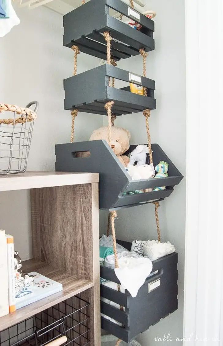 a shelf filled with lots of boxes next to a bookcase and stuffed animal on top of it