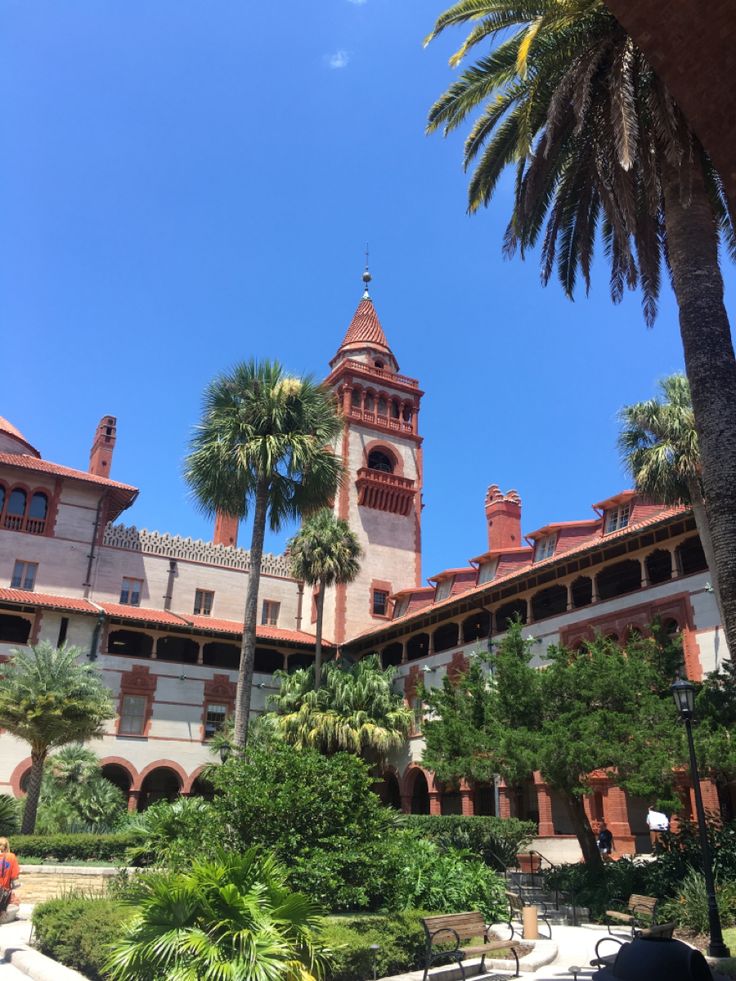 an old building with palm trees in the foreground