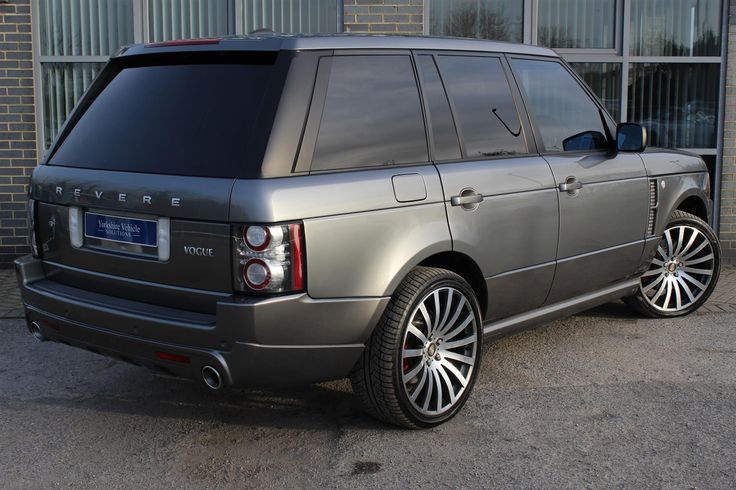 a silver range rover parked in front of a building