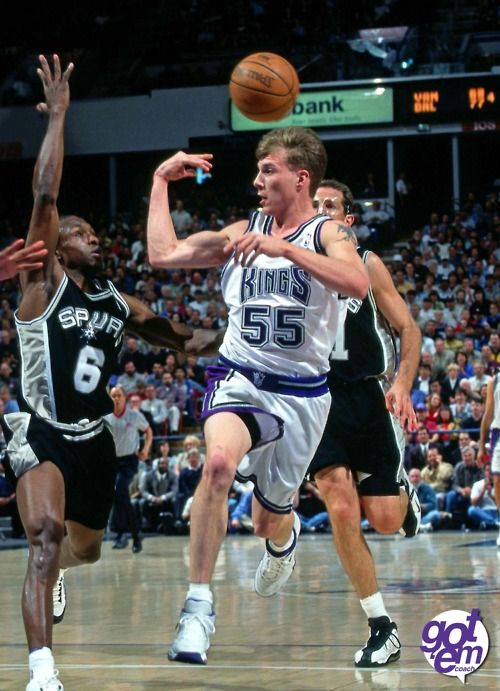 the basketball player is trying to block the ball from being guarded by two other players