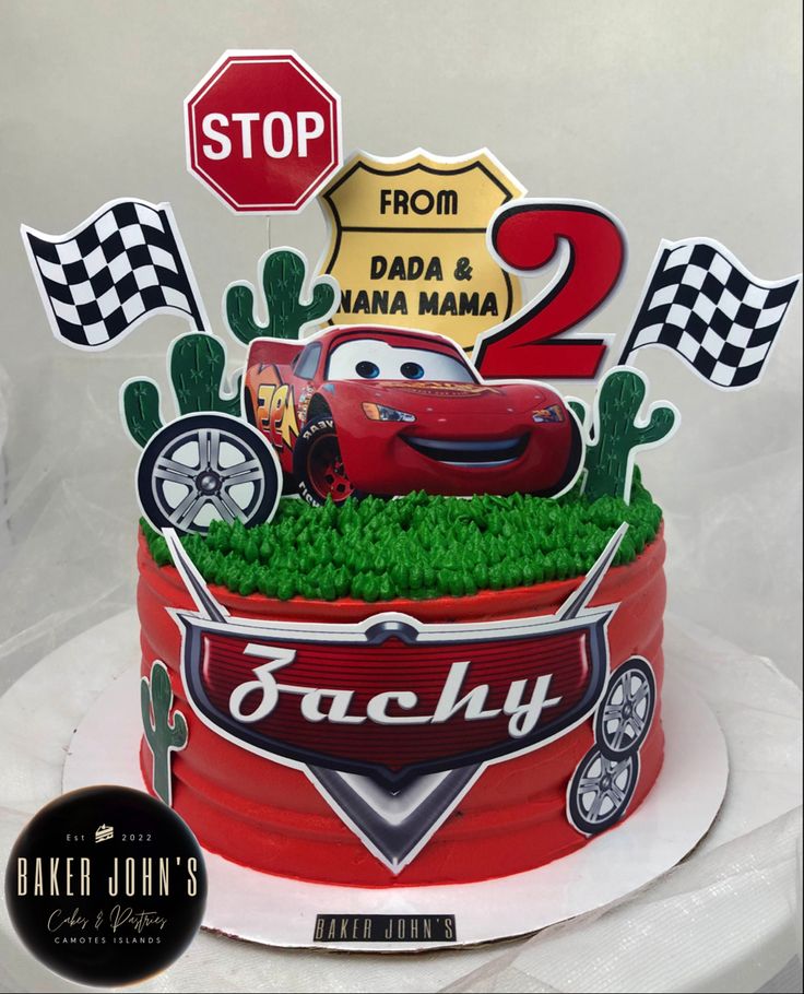 the birthday cake is decorated with cars and racing flags on it's top tier