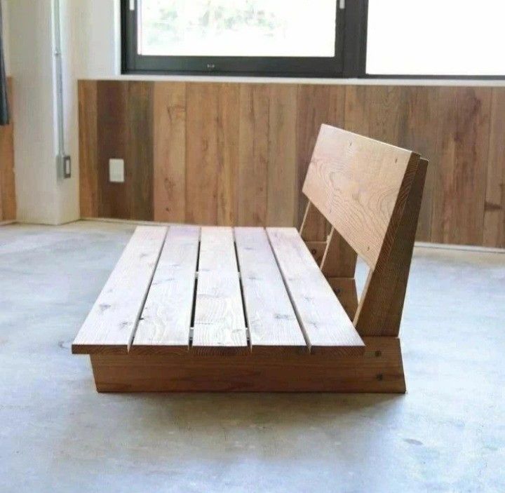 a wooden chair sitting on top of a floor in front of a window with wood slats