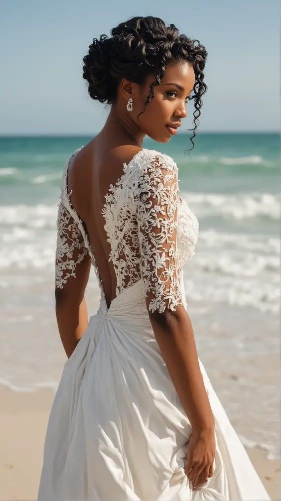 a woman standing on top of a beach next to the ocean wearing a white dress