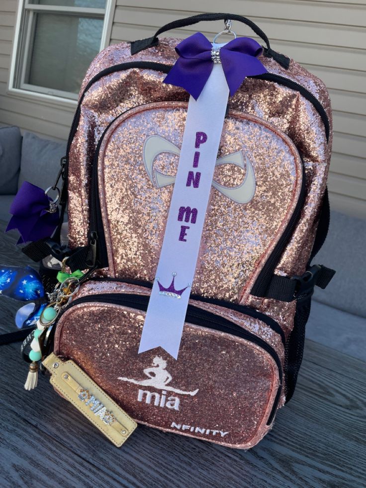 a back pack with a purple ribbon on the front and pink sequins on the back