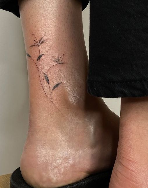 a woman's foot with a small flower tattoo on her left side calfocks