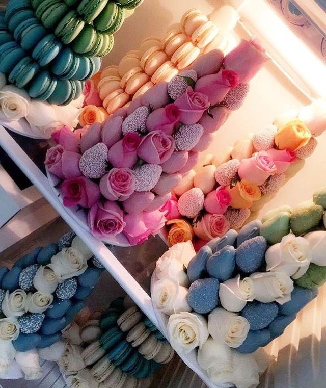 there are many different types of donuts in the display case, including roses and macaroons