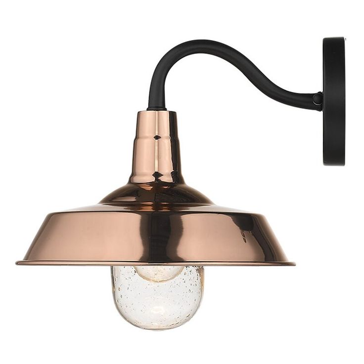 the copper and black light fixture is mounted on an iron wall bracket with a glass globe shade