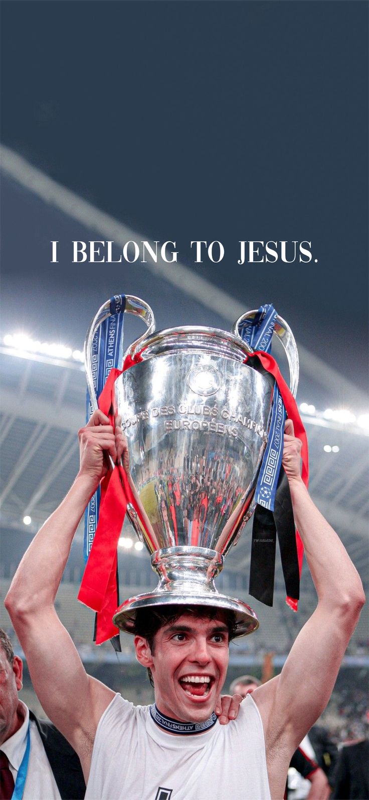 a man holding up a trophy in front of his face with the words i belong to jesus